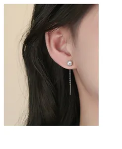 Detailed close-up view of shimmering cubic zirconia tassel chain stud earrings worn.