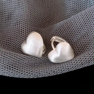 Orecchini a cerchio con cuore spazzolato argentato da donna, design geometrico minimalista chic.