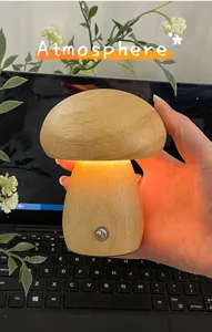 Hand die een gloeiend massief houten paddenstoel LED-nachtlampje vasthoudt