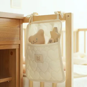 Detailansicht der cremefarbenen gesteppten Babybett-Hängetasche mit Herzmuster