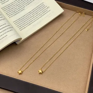 Detalle de un collar de cadena minimalista chapado en oro de 24K con colgante de estrella 3D