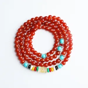 Vista dettagliata del bracciale con 108 perle di agata rossa naturale e distanziatori.