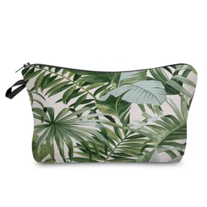 Close-up detail of tropical green leaves pattern makeup bag with black zipper and side strap.