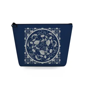 Blaues Kosmetiktäschchen mit detailliertem weißem Retro-Blumenmuster und schwarzem Reißverschluss.