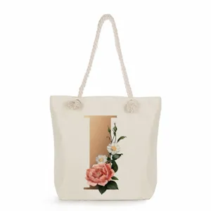 Canvas tote bag for women, large capacity shoulder bag with gold letter floral print and rope handles.