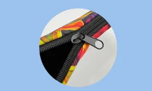 Close-up detail shot of colorful monstera leaf print cosmetic bag zipper and textured fabric.