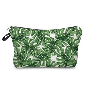 Green monstera leaf print cosmetic bag detail, featuring durable fabric and smooth black zipper.