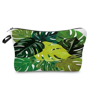 Close-up of tropical monstera leaf print cosmetic bag with vibrant green patterns.
