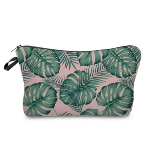 Close-up detail of tropical palm and monstera green leaf print cosmetic bag zipper side.