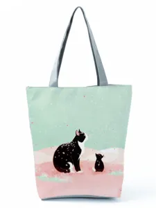 Gros plan du sac cabas imprimé chat mignon, tissu vert menthe avec motif d'animaux.