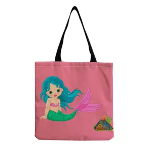 Pink canvas tote bag featuring cute cartoon mermaid print, black straps, detailed view.