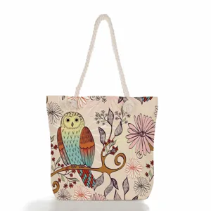 Amplio bolso de playa de lona con bonito estampado de búho y flores, asas de cuerda.