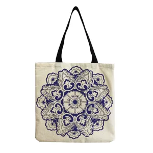 Close-up detail of the vintage blue floral print canvas shoulder tote bag with black handles.
