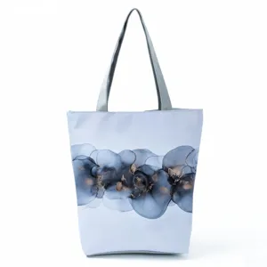 Detailed close up view of the stylish blue abstract ink pattern tote bag with grey straps.