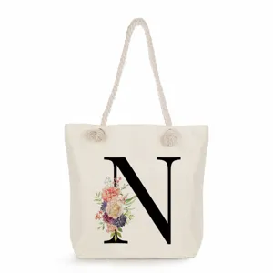 Stofftasche mit Blumenbuchstaben Druck und Kordelgriffen für Strand Einkäufe und Alltag.