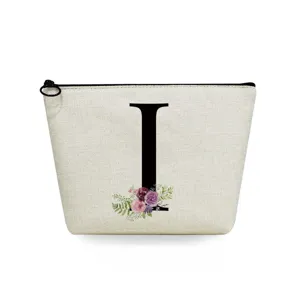 Detail view of a beige linen makeup pouch featuring a black letter I and floral print.