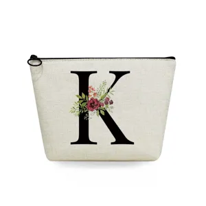 Canvas cosmetic bag detail, featuring black letter K print and watercolor floral pattern.