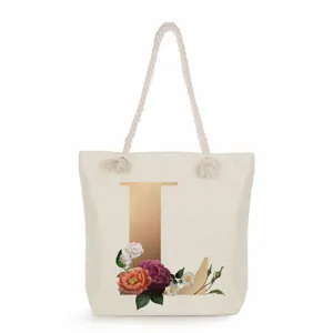 Canvas tote bag featuring gold letter L print and elegant floral details for daily use.