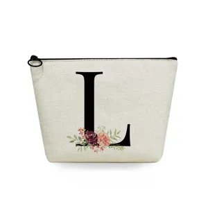 Detail shot of canvas makeup pouch featuring elegant floral letter print and black zipper closure.