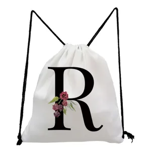 White canvas drawstring backpack featuring a bold black letter R print with delicate floral details.