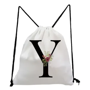 Close-up detail of the white canvas drawstring backpack featuring a black letter Y print.