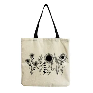Canvas tote bag detail showing elegant black floral line art print and durable black straps.