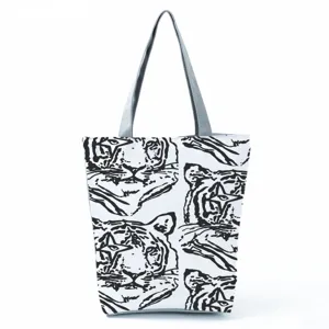 Close up detail of white canvas tote bag with abstract black tiger face graphic print pattern.