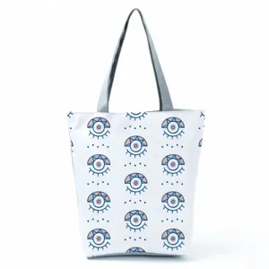 Detailed view of the stylish canvas tote bag featuring a repeating abstract eye pattern design.