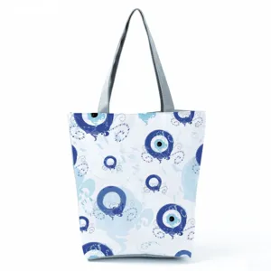 Large capacity canvas tote bag with stylish blue evil eye print, casual shoulder bag for daily use.