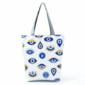 Close-up of the stylish evil eye patterned canvas tote bag with durable grey shoulder handles.