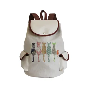 Detailed view of cute cat print canvas backpack with brown trim and dual front pockets.
