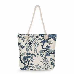 Close-up detail of canvas tote bag with classic blue and white floral pattern and rope handles.