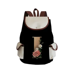 Detail view of the stylish canvas backpack showcasing the floral letter print and brown leather trim.