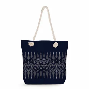 Canvas tote bag detail, dark blue shoulder bag with geometric pattern and rope handles.