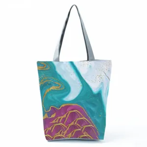 Close-up of the abstract teal and purple fluid pattern canvas tote bag with gold lines.