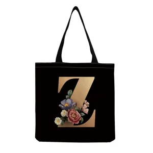 Close-up detail of the black canvas tote bag featuring gold letter Z and vintage floral print.