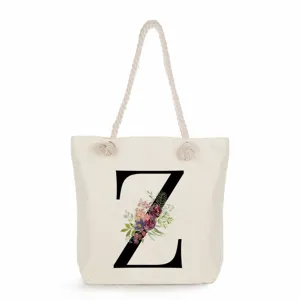 Strapazierfähige Segeltuch-Tragetasche mit gedrehten Griffen und Blumen-Buchstaben-Print.