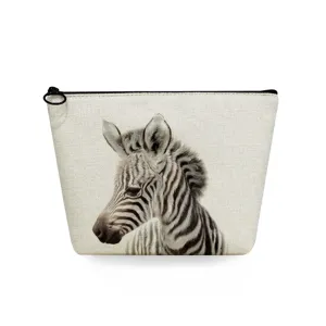 Detail view of the zebra print cosmetic pouch featuring a durable black zipper and ring.