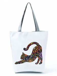 Vue détaillée de l'imprimé chat floral artistique sur le sac cabas blanc élégant.
