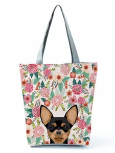 Gros plan détaillé de l'imprimé floral et du motif de chien mignon sur le sac fourre-tout.