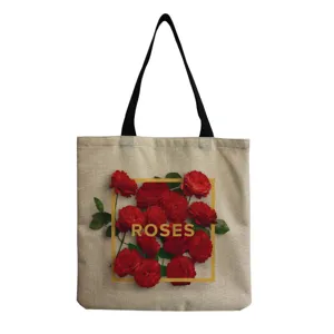 Detailed view of the linen tote bag featuring vibrant red roses and gold lettering print.