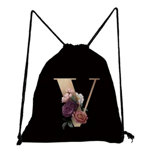 Detailansicht des schwarzen Kordelrucksacks mit goldenem V-Buchstaben und Blumen-Grafikprint.