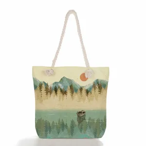 Λεπτομέλεια τσάντας tote από καμβά με vintage εκτύπωση τοπίου και ανθεκτική λαβή από σχοινί.