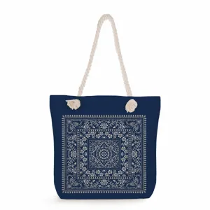 Blue canvas tote bag detailed view, featuring vintage white floral pattern and thick rope handles.