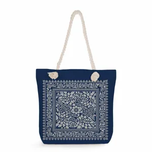 Blue canvas tote bag with white rope handles and elegant floral bandana pattern print.