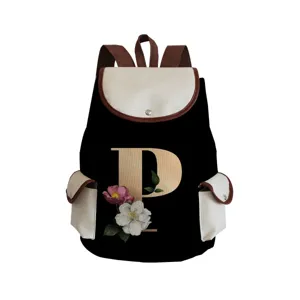 Details of the canvas backpack featuring a vintage floral letter P print and cream flap pockets.
