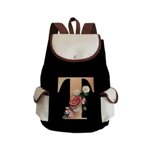 Detailed view of canvas backpack with floral letter T print, showing textured fabric quality.