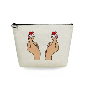 Canvas cosmetic pouch detail showing finger heart graphic print and smooth zipper closure.