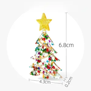 Primer plano de un pendiente de árbol de navidad de acrílico con estrella dorada y estrás.