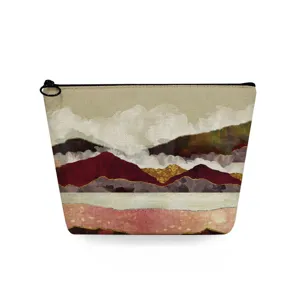 Detail van het make-up tasje met abstract landschap print en artistieke bergen details.